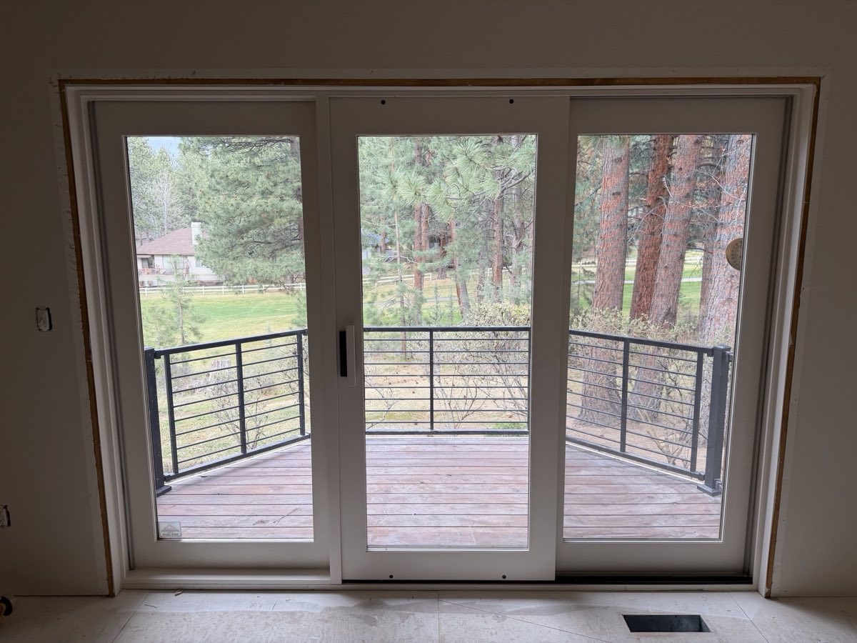 Painted sliding door trim with a view to the deck and pines