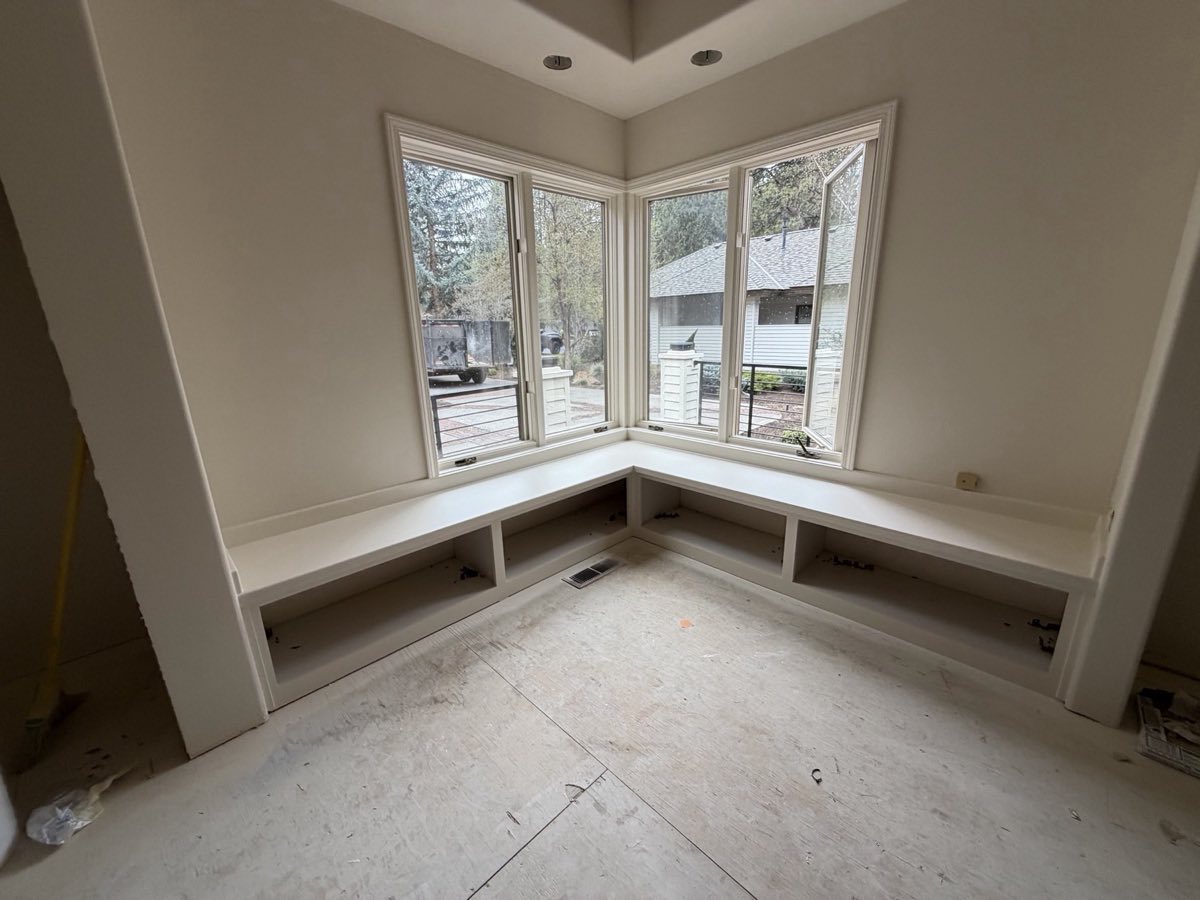 Built-in corner window seat converted from clear-coated oak to a painted white finish by Keystone Painting LLC in Bend, Oregon