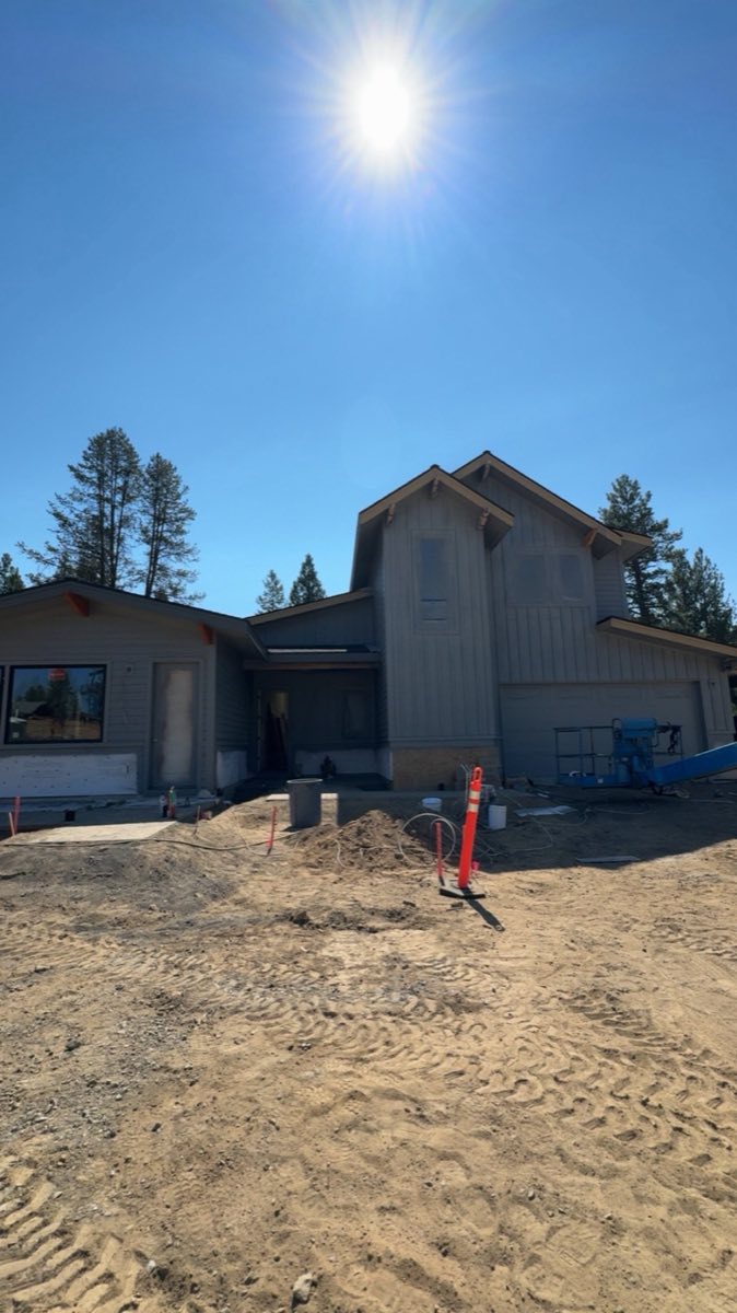 New construction home exterior being painted from a boom lift in the Caldera Springs neighborhood of Sunriver, Oregon, by Keystone Painting LLC